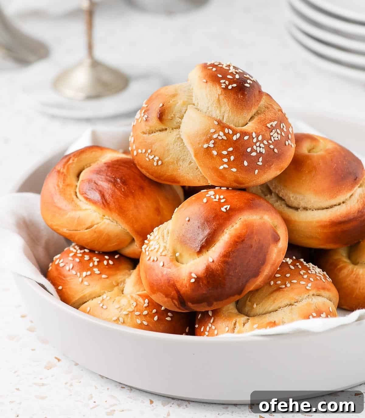 Soft and Fluffy Challah Dinner Rolls: Perfect for Any Meal 9 Rolls stacked in a large light grey bowl.