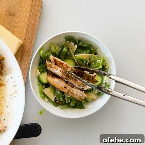 Lemon Chicken Caesar Salad with Cottage Cheese Twist 7 Adding chicken to the top of lemon caesar salad.