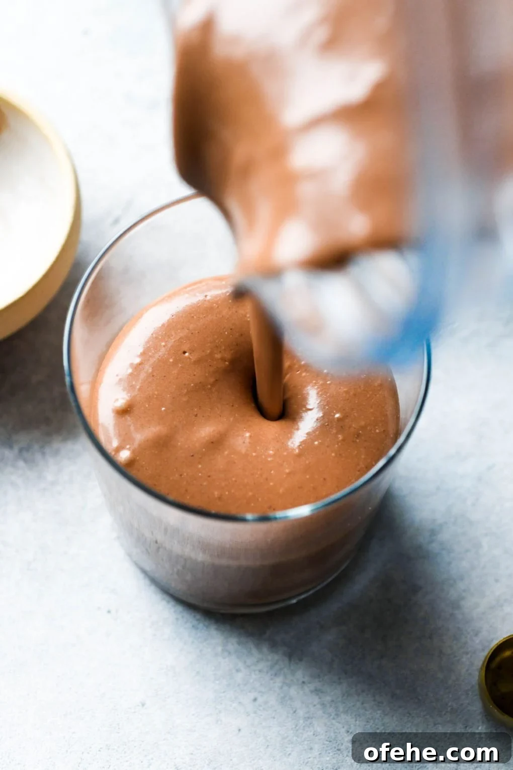 Close up shot of pouring the chocolate mousse mixture into a cup.
