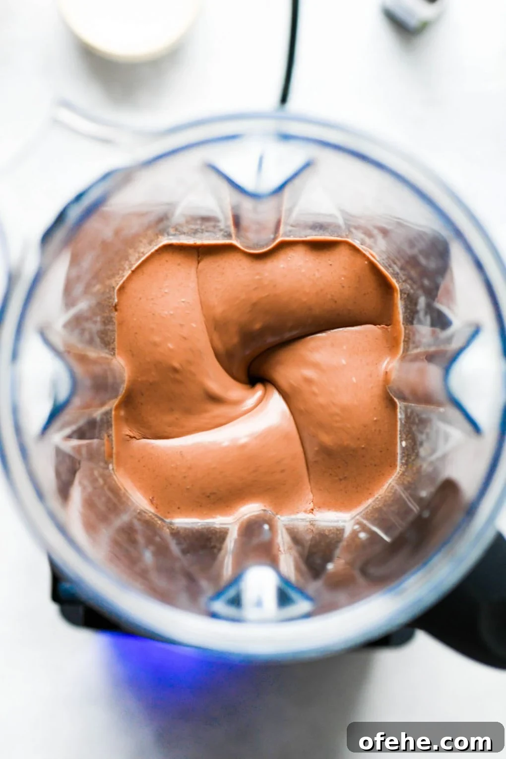 Overhead view of vegan chocolate mousse whirring in a blender.