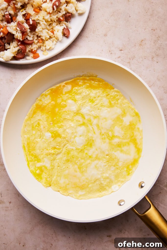 Hot Dog Fried Rice Recipe — Quick Weeknight Meal 7 eggs cooking in a skillet