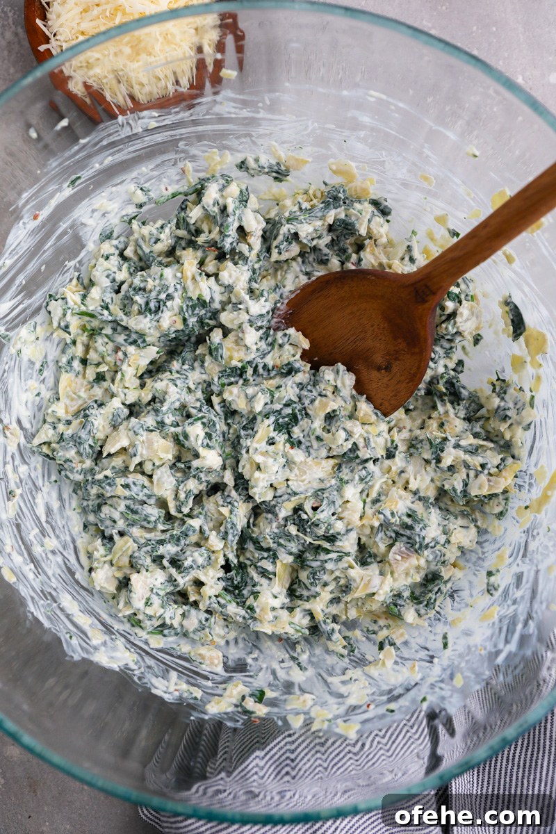 Crispy Baked Spinach and Artichoke Bites You'll Love 4 A large clear mixing bowl filled with a lightened up spinach artichoke dip
