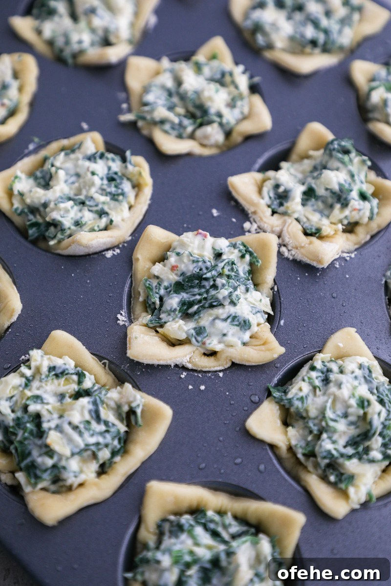 Crispy Baked Spinach and Artichoke Bites You'll Love 5 A mini muffin tin filled with puff pastry cut into squares and each square filled with spinach artichoke dip
