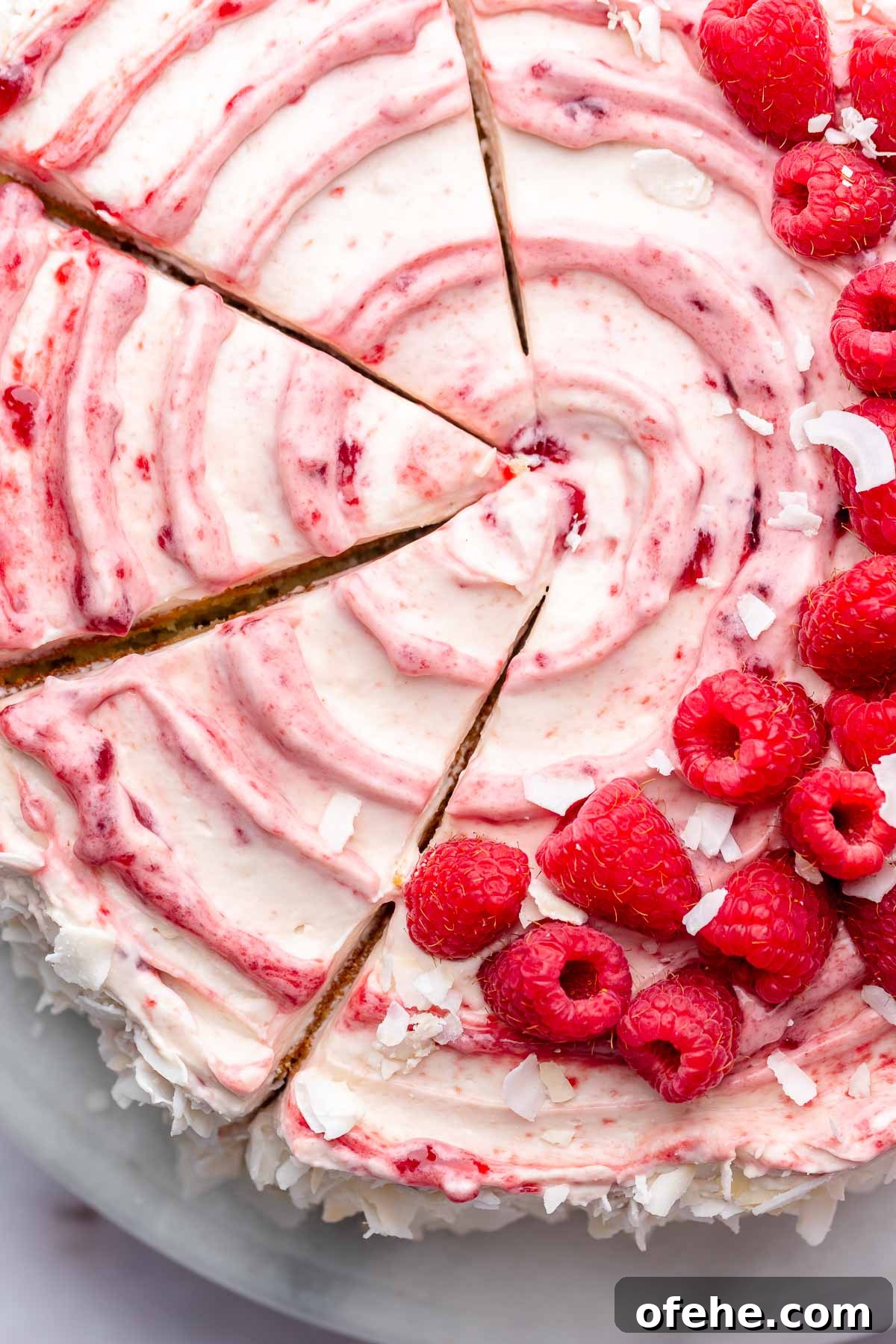 Raspberry Coconut Cake Recipe with Creamy Coconut Frosting 17 Sliced raspberry coconut cake on a cake stand.