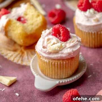 Raspberry white chocolate cupcake on a small plate.