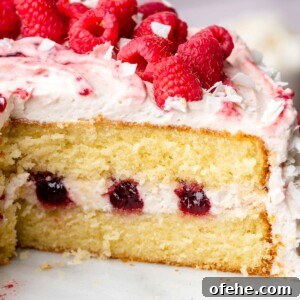Raspberry Coconut Cake Recipe with Creamy Coconut Frosting 23 Sliced raspberry coconut cake on a cake stand.