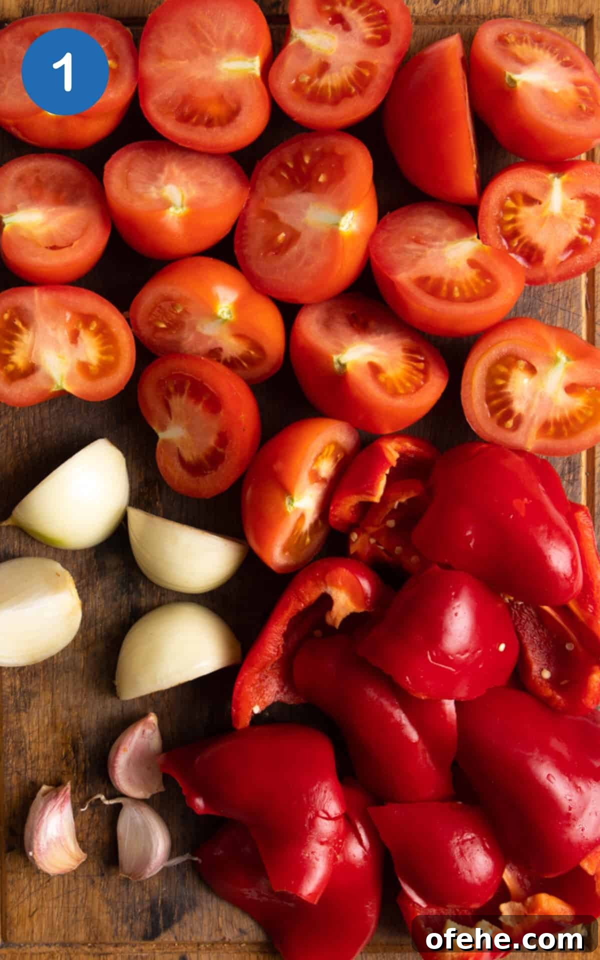 Roasted Red Pepper & Tomato Soup Recipe for Cozy Weeknights 4 chopped tomatoes, pepper, onion and garlic on a wooden chopping board.