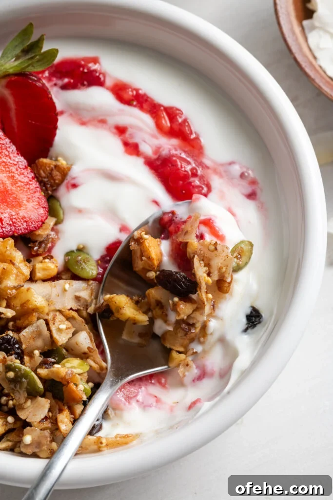 Grain-Free Homemade Granola Recipe with Crunchy Seeds 13 closeup shot of a white bowl filled with yogurt topped with grain free granola, fresh strawberries, and strawberry chia jam.