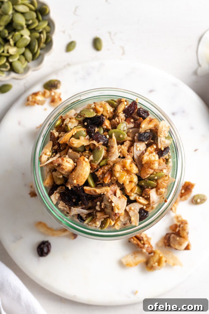 Grain-Free Homemade Granola Recipe with Crunchy Seeds 15 flat lay shot of grain-free granola in a jar on a white marble round serving tray on a white table with some of the granola scattered around.