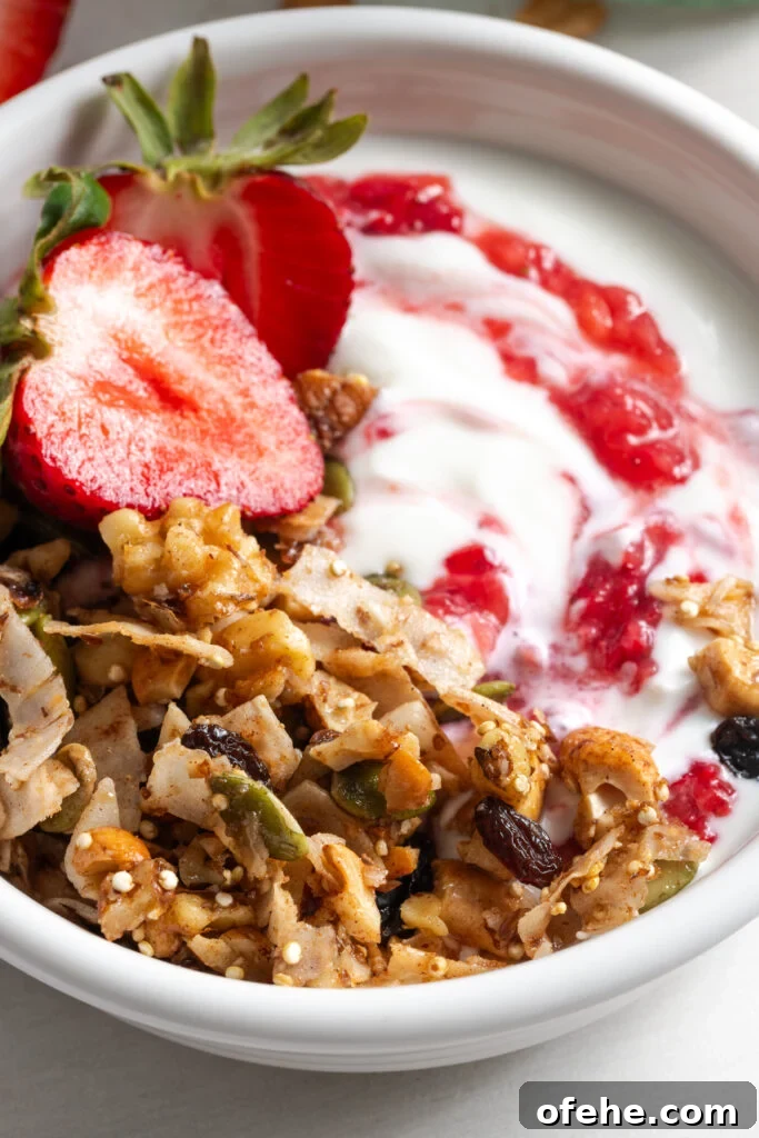 Grain-Free Homemade Granola Recipe with Crunchy Seeds 16 closeup shot of a small bowl of yogurt topped with grain-free oat free granola and strawberry jam.