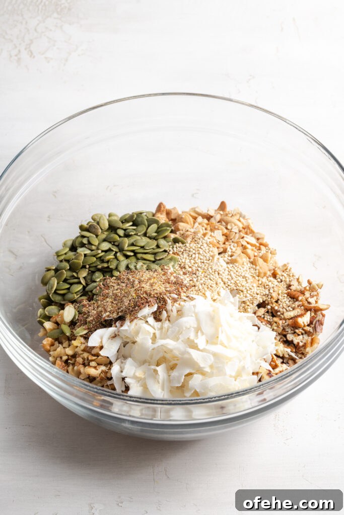 Grain-Free Homemade Granola Recipe with Crunchy Seeds 7 dry oat-free granola ingredients added to a mixing bowl before mixing.