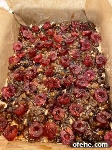 Mincemeat Slice - shortbread base with mincemeat and cherries before the topping is placed on