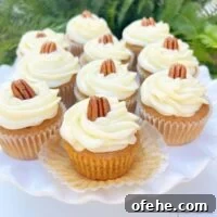 Moist Sweet Potato Cupcakes with Cinnamon Glaze 14 Cake pedestal filled with sweet potato cupcakes, topped with swirls of cream cheese frosting and pecans.