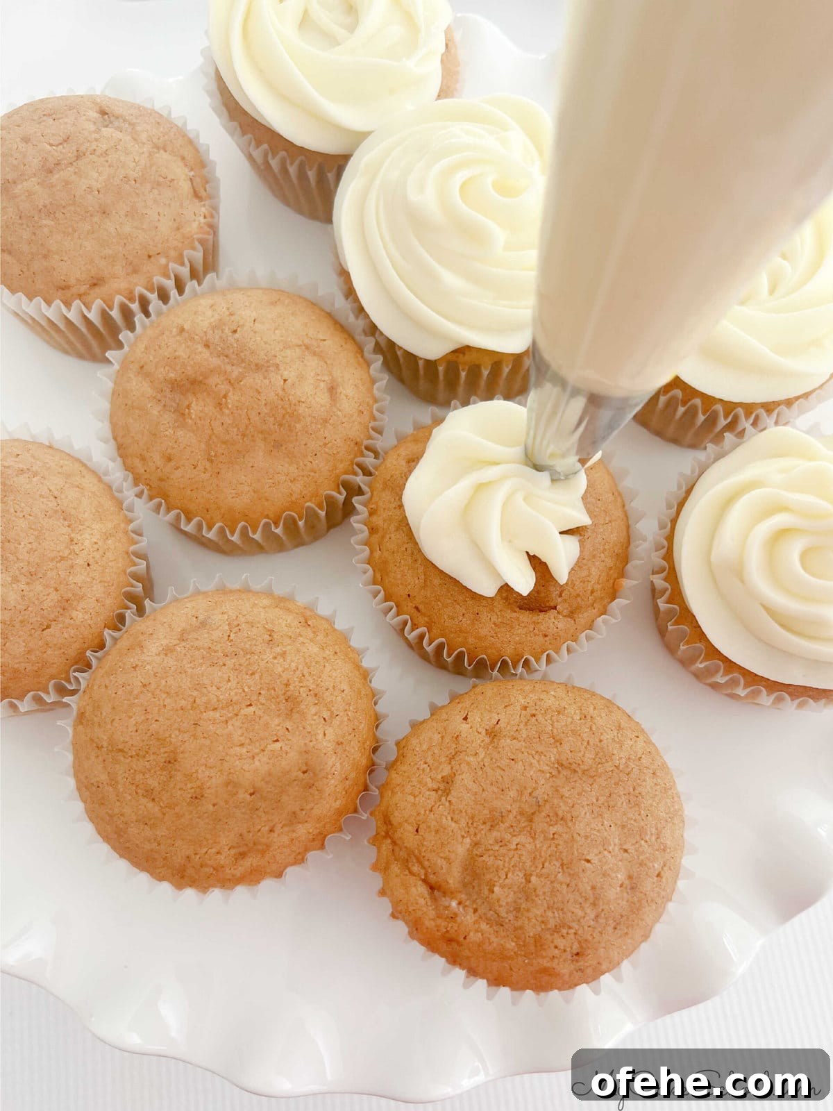 Moist Sweet Potato Cupcakes with Cinnamon Glaze 8 Piping swirls of cream cheese frosting onto the sweet potato cupcakes.