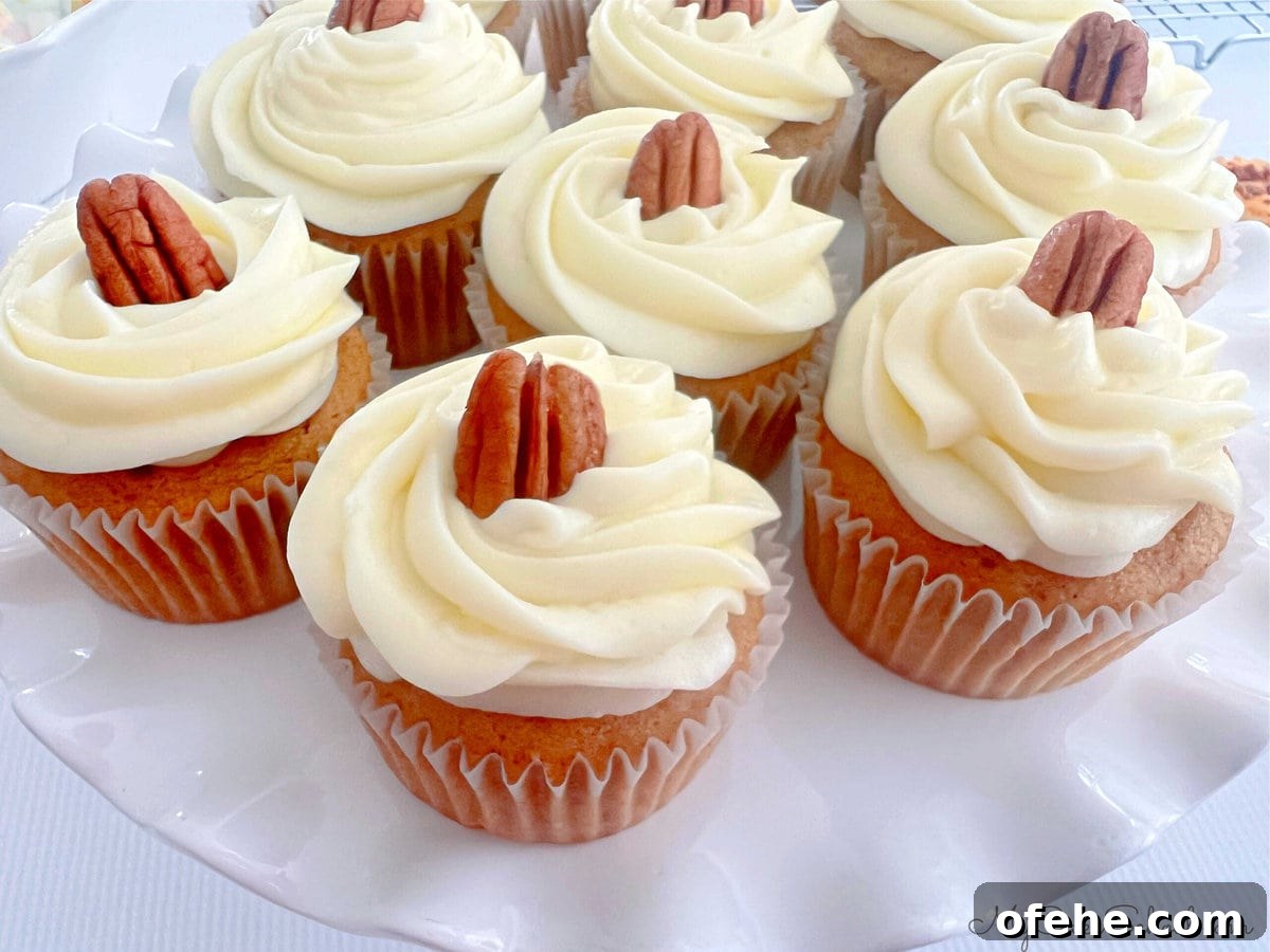 Moist Sweet Potato Cupcakes with Cinnamon Glaze 9 Sweet Potato Cupcakes, frosted and topped with pecans.