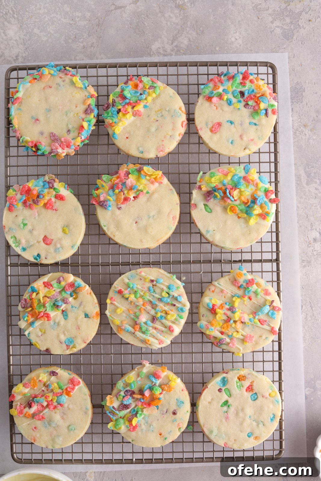 Fruity Pebbles Cookies Recipe: Colorful, Crispy Treats 9 Fruity Pebbles cookies with white chocolate on top on a baking rack.