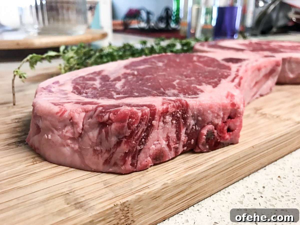 raw ribeye steak on cutting board