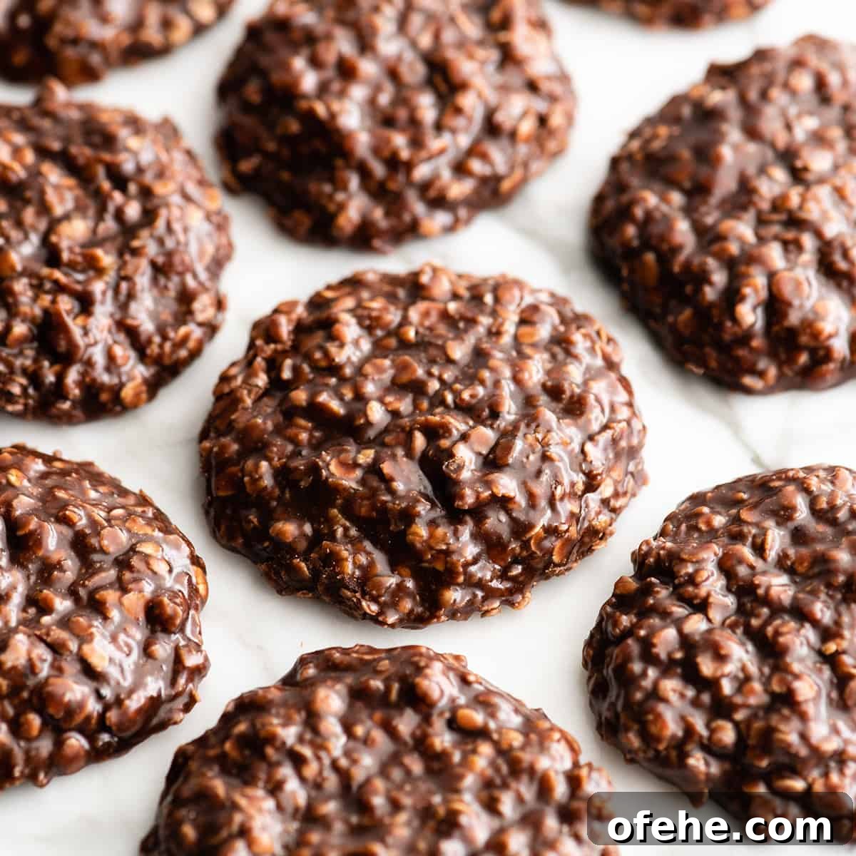 7 chocolate peanut butter no bake cookies on a white surface, the glossy fudgy texture is visible. 