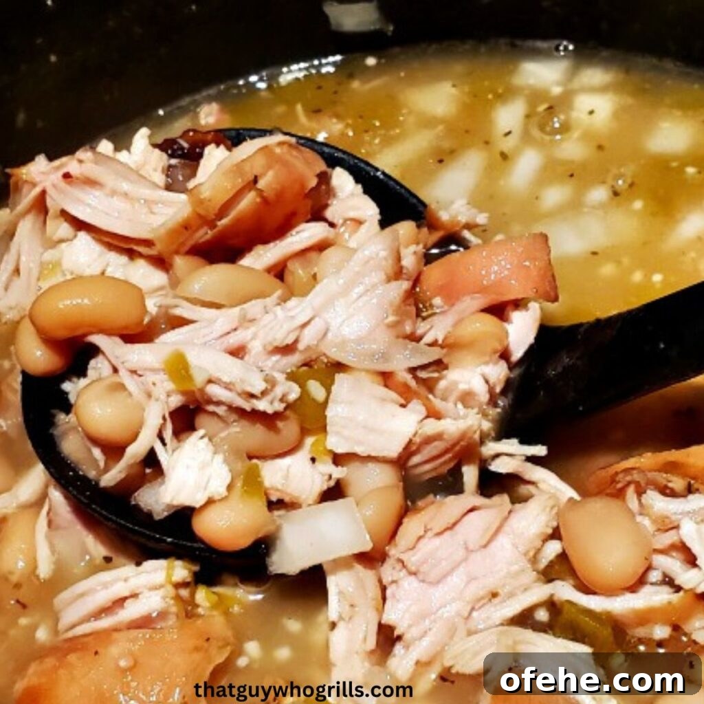 Smoked White Chicken Chili on black spoon in dutch oven
