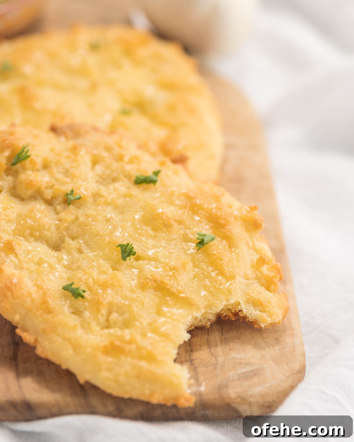 Keto-Friendly Naan Flatbread Recipe: Low-Carb Indian-Style Bread 2 Two naan flatbreads on a cutting board.
