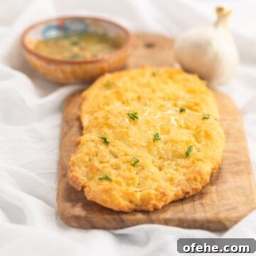 Low carb naan on a cutting board with a bowl of dipping herb oil.