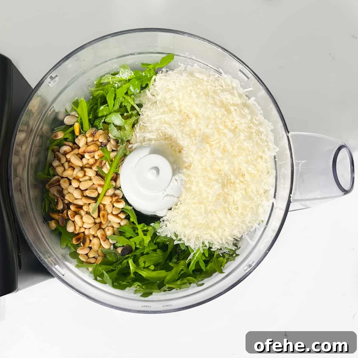Fresh Arugula Pesto Recipe: Zesty Sauce for Pasta & Sandwiches 5 All the ingredients in a food processor.