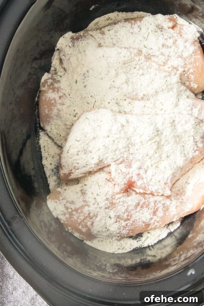 Slow-Cooker Chicken with Rich Homemade Gravy Recipe 4 chicken in crockpot with ranch powder over the top of it