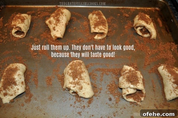 Cinnamon Roll Crescents - The Grateful Girl Cooks! Dough is rolled up and sprinkled with extra filling mixture on top.