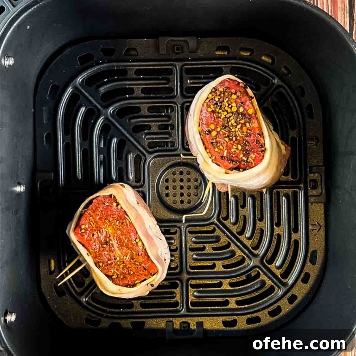 Crispy Bacon-Wrapped Filet Mignon in the Air Fryer 8 The prepared filet mignon wrapped in bacon and placed in the air fryer basket.