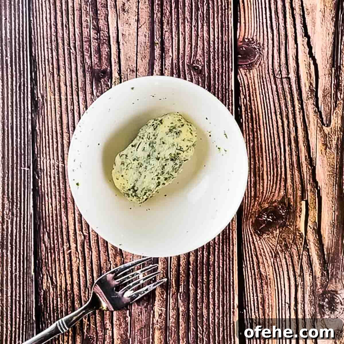Crispy Bacon-Wrapped Filet Mignon in the Air Fryer 9 The ingredients for the herb garlic compound butter mixed together in a small white bowl.