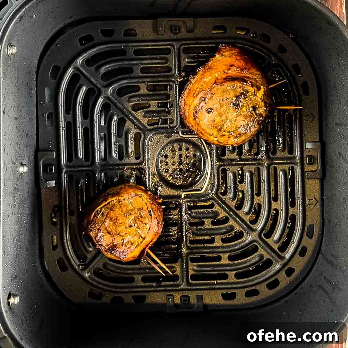 Crispy Bacon-Wrapped Filet Mignon in the Air Fryer 10 The air fried steaks in the air fryer basket at the end of the cooking time.