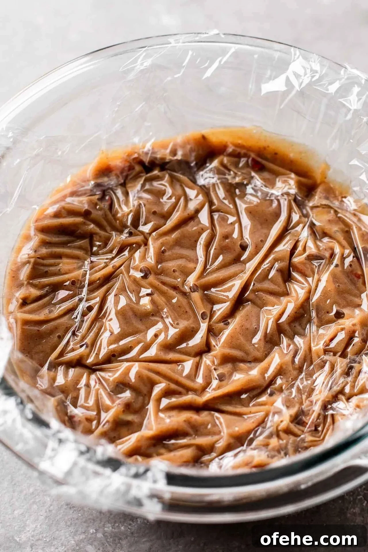 Pecan Pie Cupcakes Recipe — Classic Southern Dessert Cupcakes 7 pecan pie cupcake pudding in bowl with plastic wrap pressed against surface
