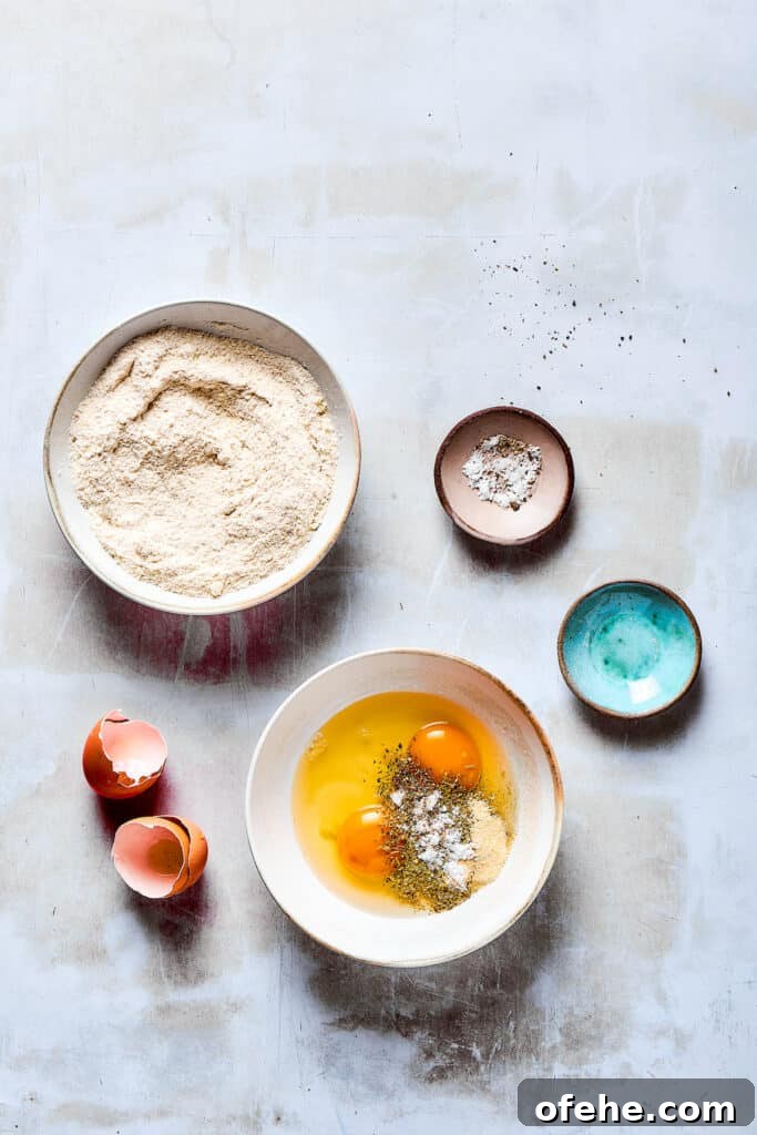 Wet and dry breading bowls. A bowl of breading ingredients next to a bowl of beaten eggs and seasonings.