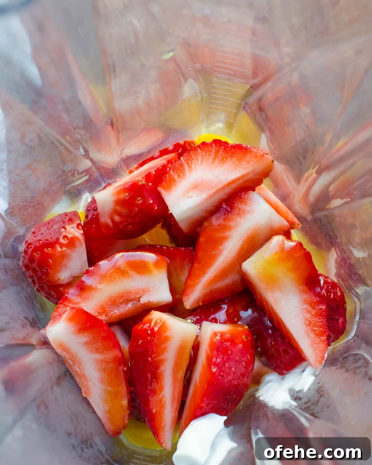 Strawberry Orange Banana Smoothie Recipe for Fresh Morning Energy 3 strawberries and honey in a blender.