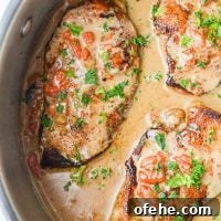 Creamy Roasted Red Pepper Chicken Recipe for Weeknight Dinners 10 A skillet filled with chicken breasts coated in a red pepper cream sauce, and garnished with parsley.