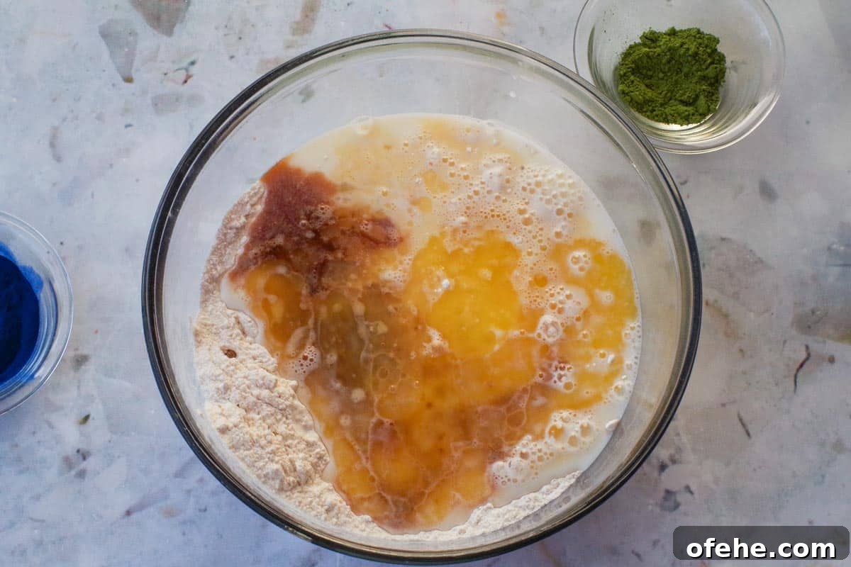 Colorful Earth Day Sheet-Pan Pancakes Recipe 7 Vanilla extract, milk and butter added with egg to dry ingredients in glass bowl
