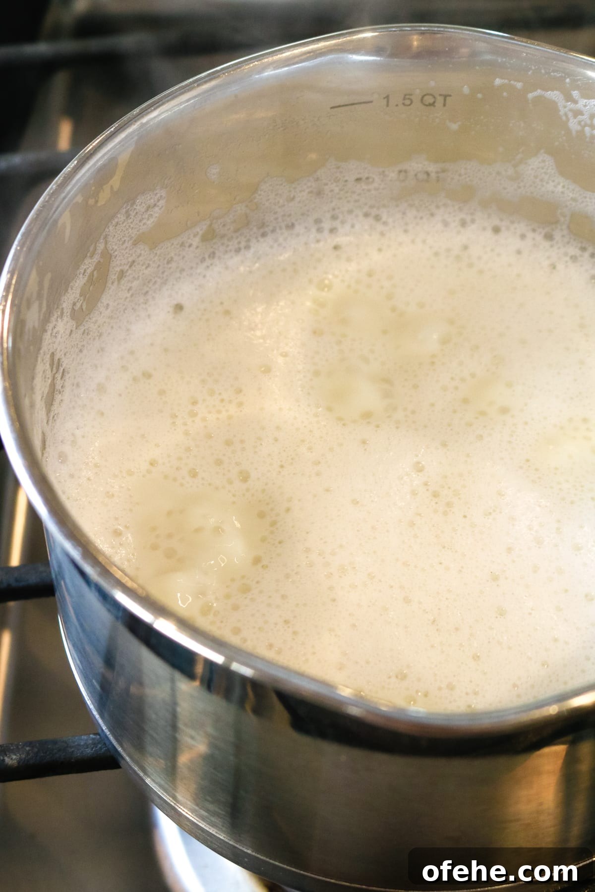 whisked milk inside of a metal pan.