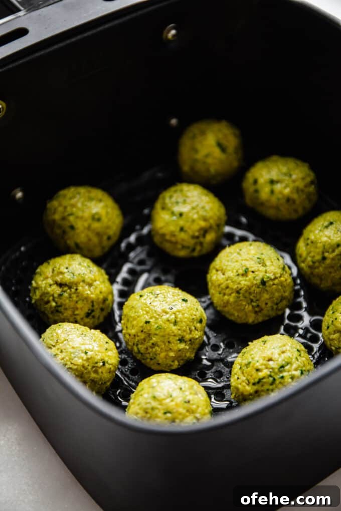 Crispy Air Fryer Falafel Recipe with Tahini Sauce 7 uncooked falafel in an air fryer basket