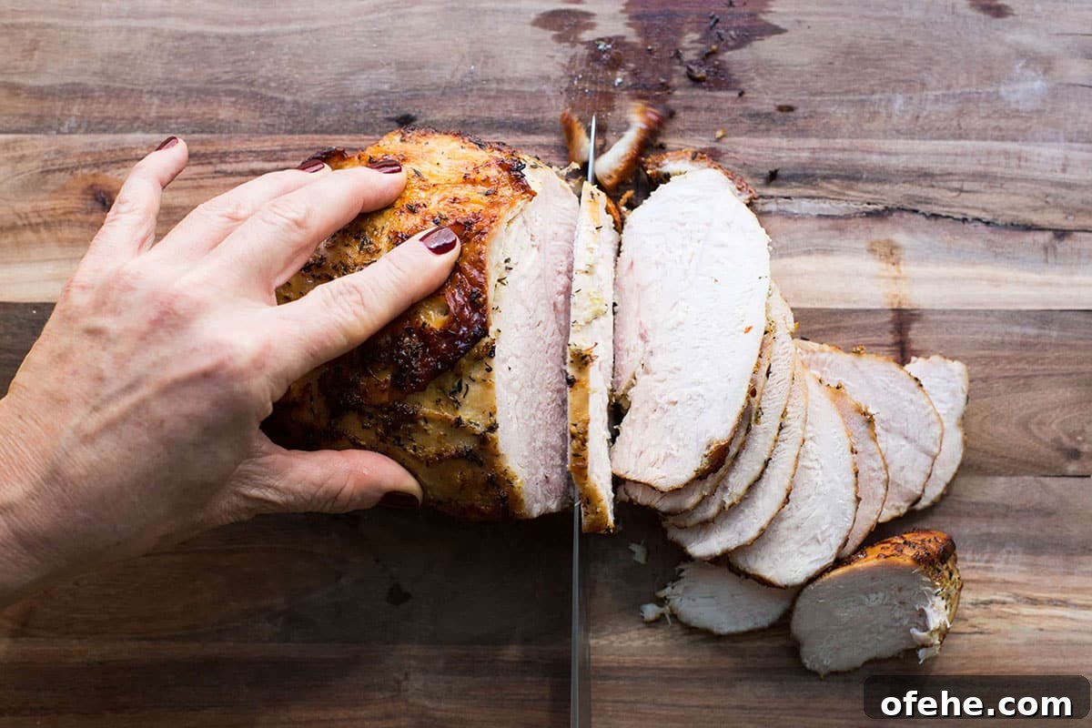 Roast Turkey Breast: Juicy Oven Method and Timing 4 Slicing Lemon-Garlic Roasted Turkey Breast on cutting board.