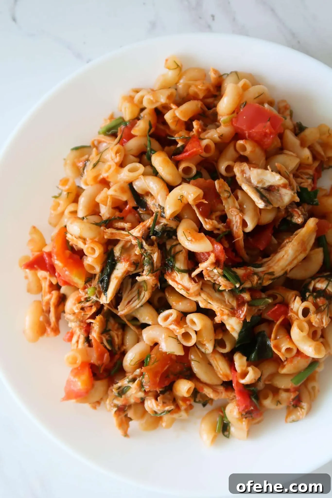10-Minute shredded chicken macaroni recipe! Make this easy shredded chicken recipe using leftovers in 10 minutes, it’s a super tasty and quick healthy dinner recipe that the entire family will love as well! This easy pasta dish  is a super healthy version of macaroni and cheese filled with fresh tomatoes, garlic, herbs, chicken and some cheese. Easy, quick, healthy and delicious!