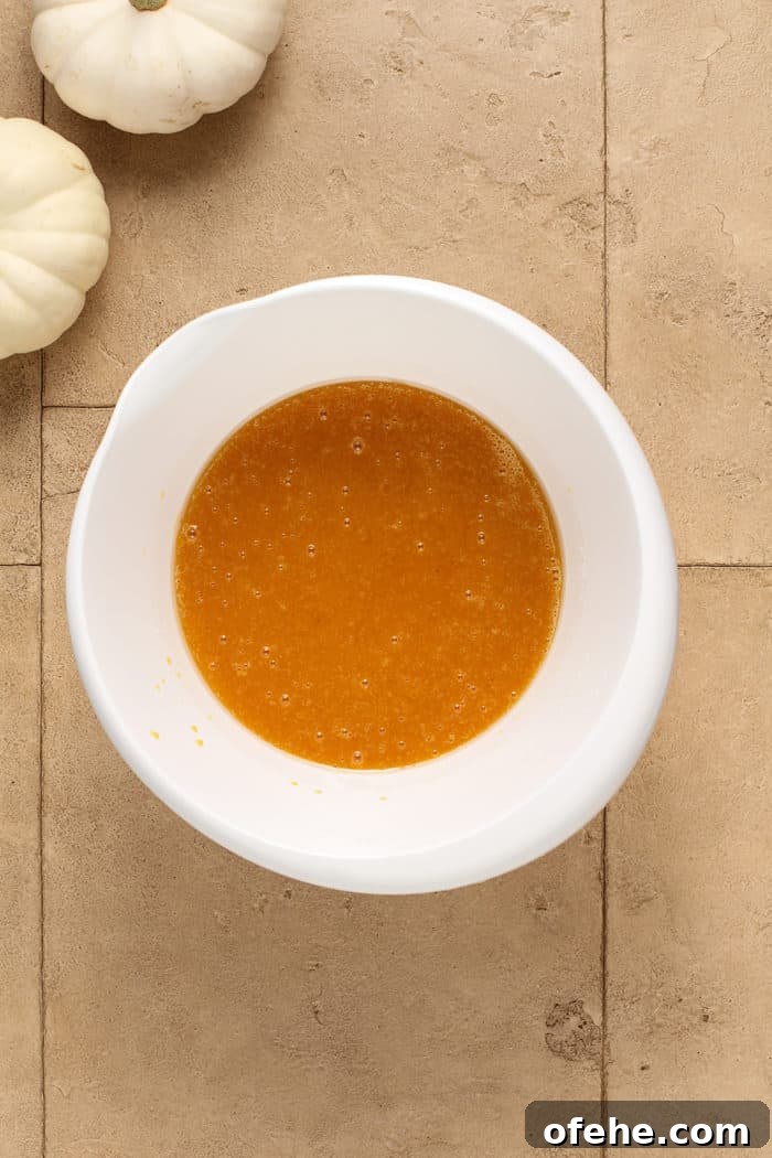 Moist Pumpkin Muffins with Warm Spices Recipe 4 Wet ingredients for pumpkin muffins in a white mixing bowl