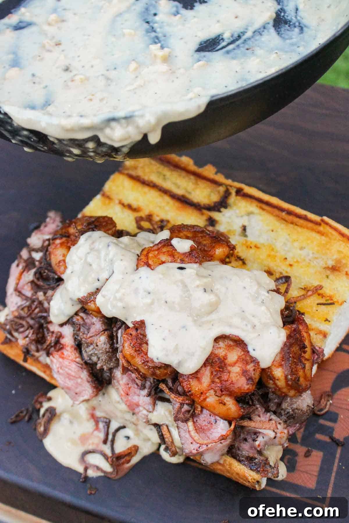 Top Surf and Turf Recipes for Dinner: Steak and Seafood Ideas 38 Adding the sauce to the surf and turf sandwich.