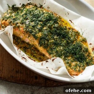 Oven-Baked Dijon Salmon with Fresh Dill and Lemon 7 Dijon mustard dill salmon after being cooked in a baking dish with parchment paper.