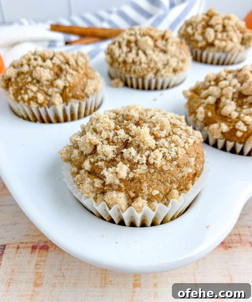 Pumpkin Streusel Muffins with Cinnamon Crunch Topping 7 An up close view of a muffin in a muffin pan. The other muffins are in the background.