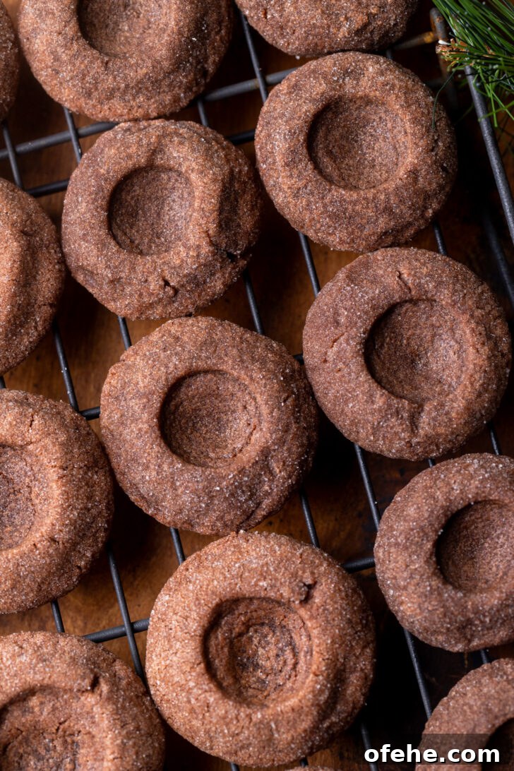 Chocolate Thumbprint Cookies with Gooey Jam Centers 7 Baked cookies on a wire rack.