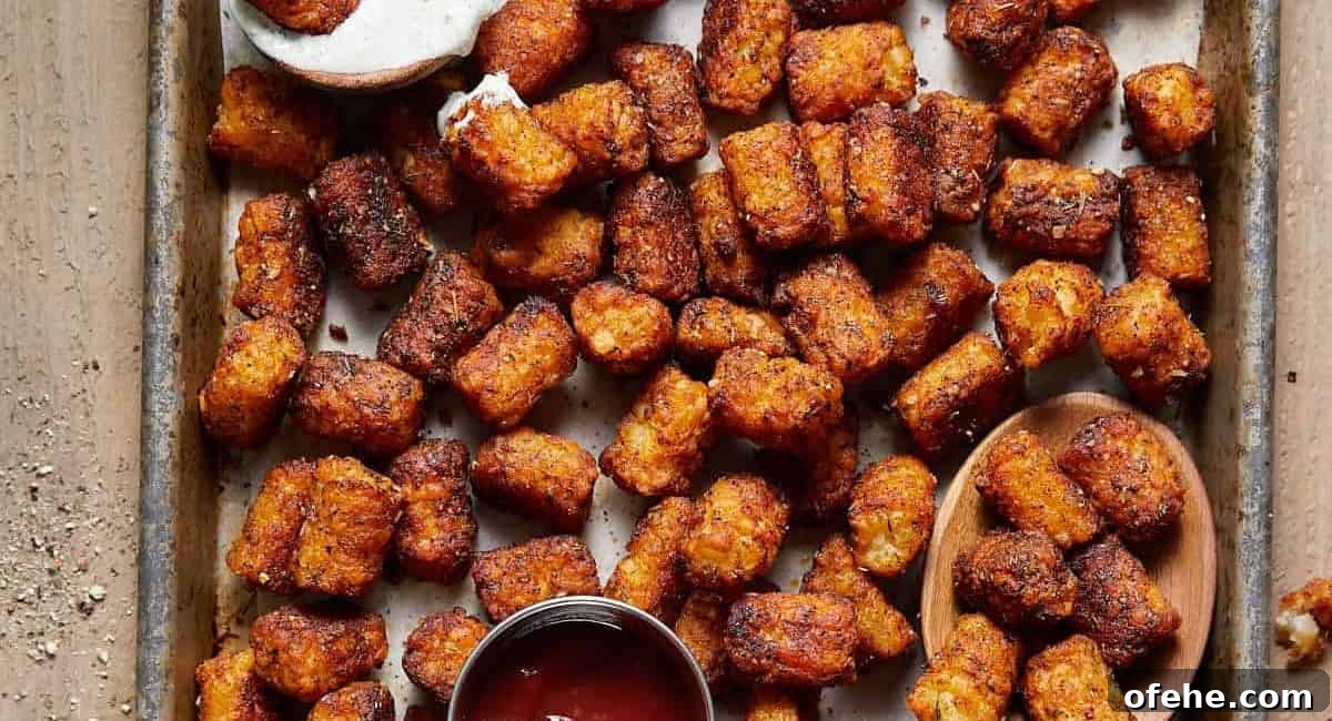Overhead image of seasoned tater tots on baking sheet.