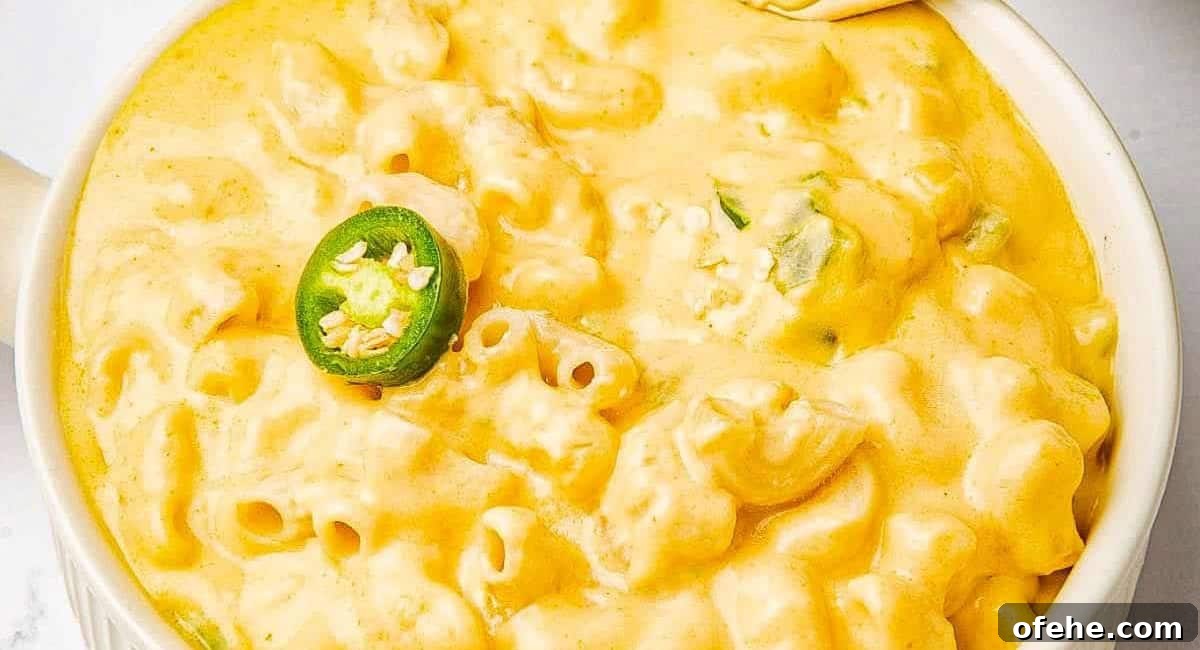 Overhead image of spicy jalapeno mac and cheese in white dish with jalapeno slice garnish.
