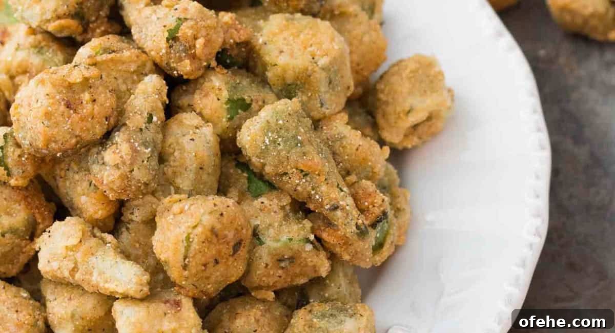 Up close image of southern fried okra with cornmeal on a white dish.