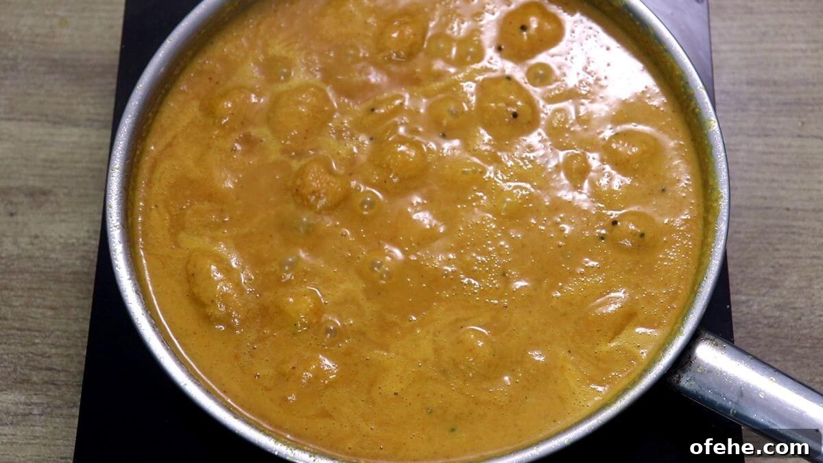 mango sasav curry simmering in the pan.