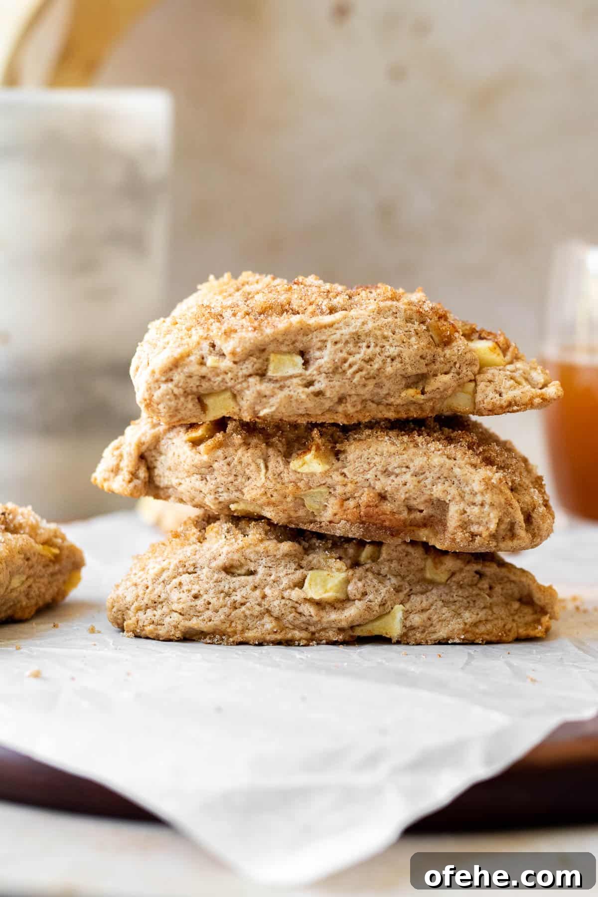 Apple Cinnamon Scones with Crunchy Cinnamon Streusel Topping 3 stack of apple scones on a parchment lined wooden cutting board with a marble utensil holder in the background